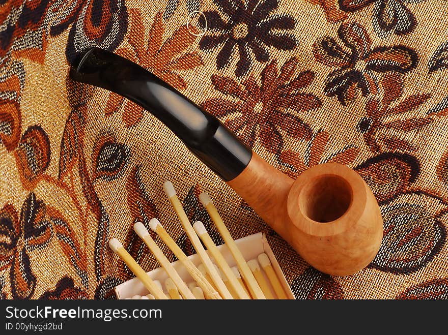 Old pipes with closeup of white tipped wooden match sticks in a match box