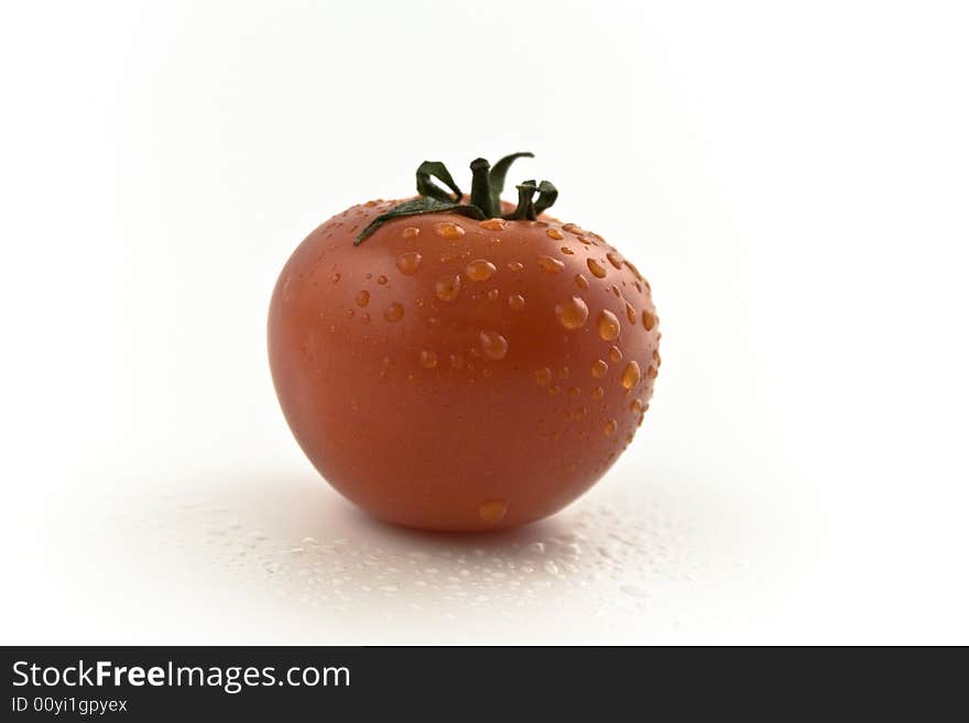 One fresh red tomato with drops close-up