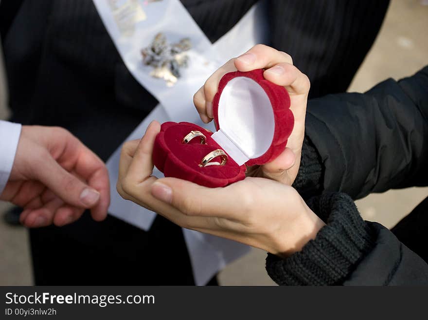 Box With Golden Rings In Hands