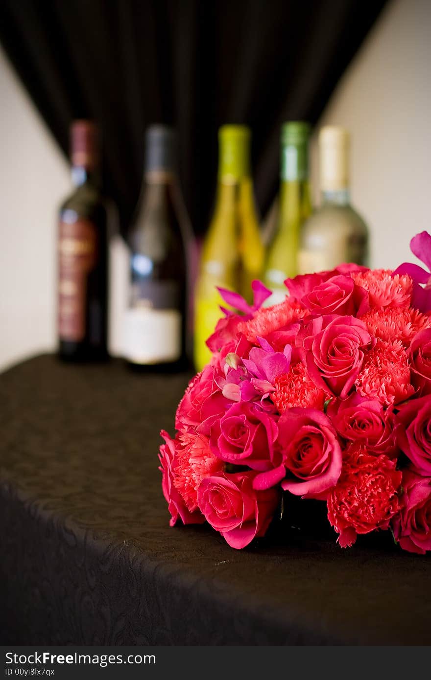 A series of five wine bottles set behind a flower arrangement. A series of five wine bottles set behind a flower arrangement