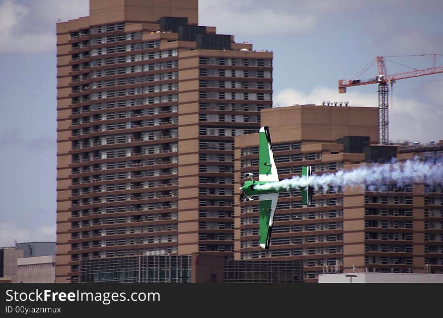 A green plane racing through the city. A green plane racing through the city.