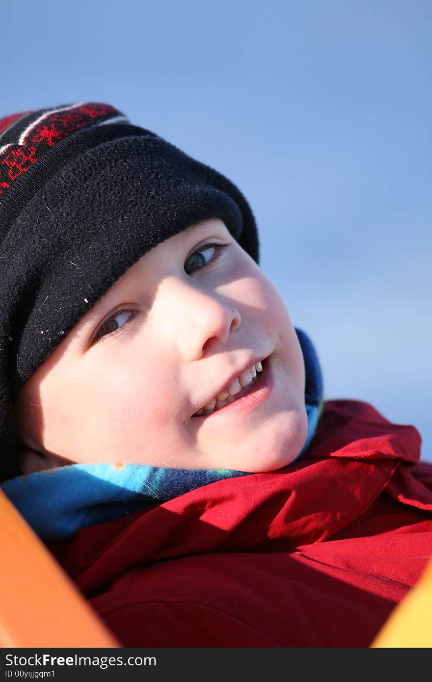 Cute boy leaning back against a slide and smiling. Cute boy leaning back against a slide and smiling.