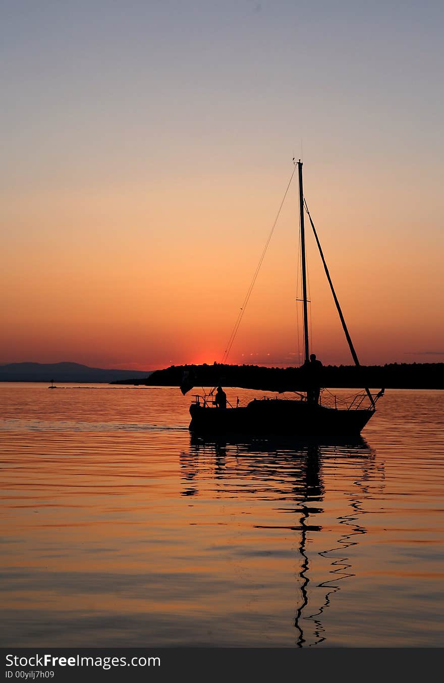 Silhouette of a single sail boat at sunset. Silhouette of a single sail boat at sunset.