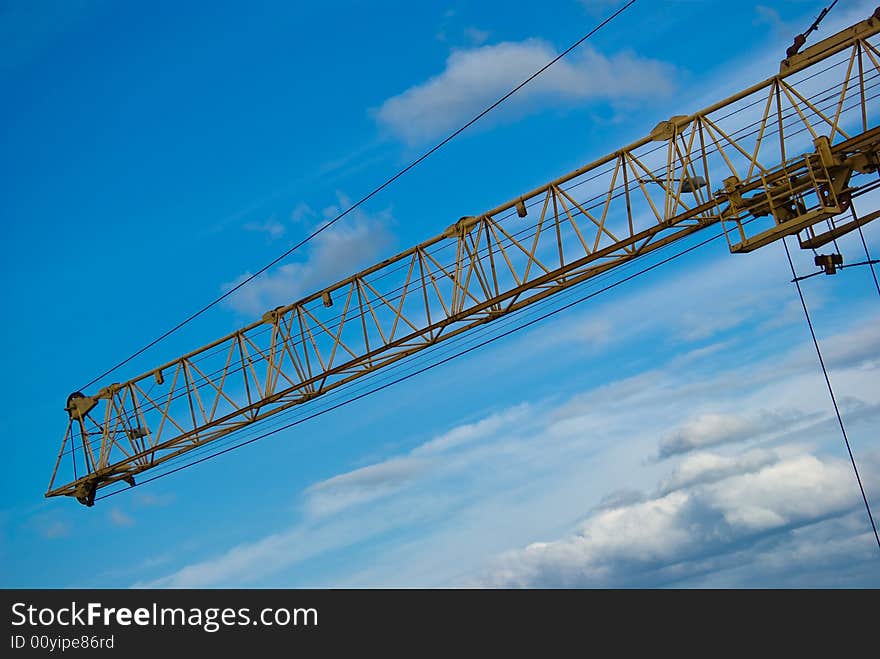 The elevating Crane, blue Sky and Clouds