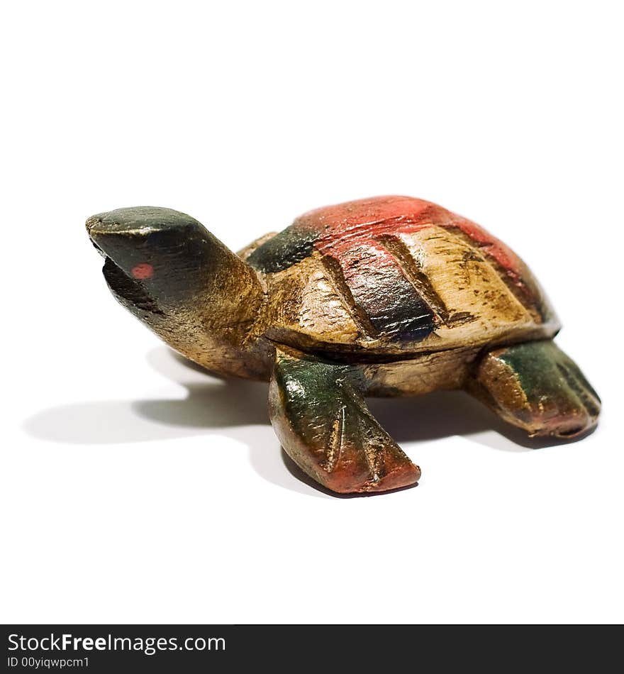 An isolated wooden toy shaped like a tortoise. An isolated wooden toy shaped like a tortoise.