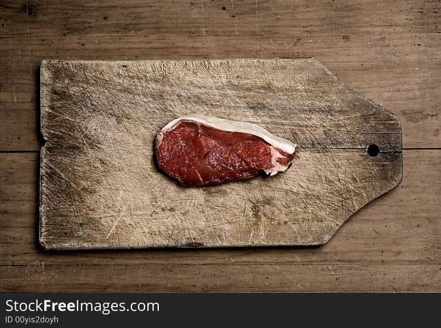 Beef steak on wood table, studio shot. Beef steak on wood table, studio shot.