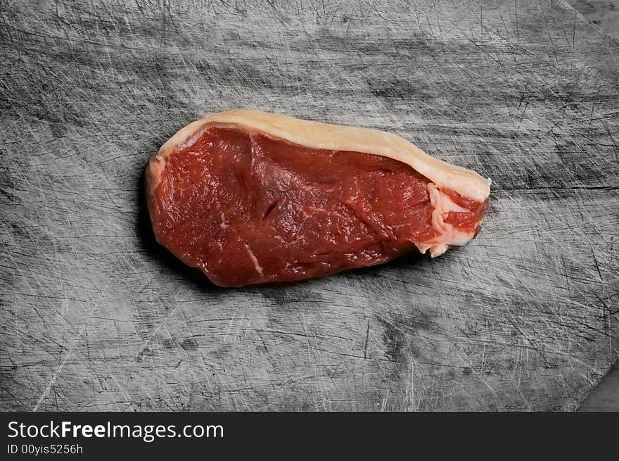 Beef steak on wood table, studio shot. Beef steak on wood table, studio shot.