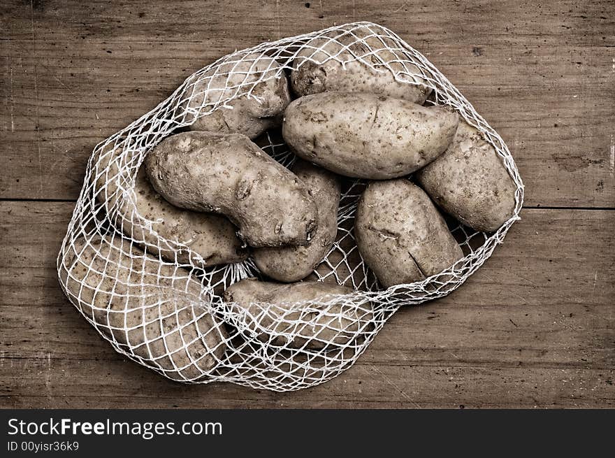 Potatoes on wooden table. A studio shot. Potatoes on wooden table. A studio shot.