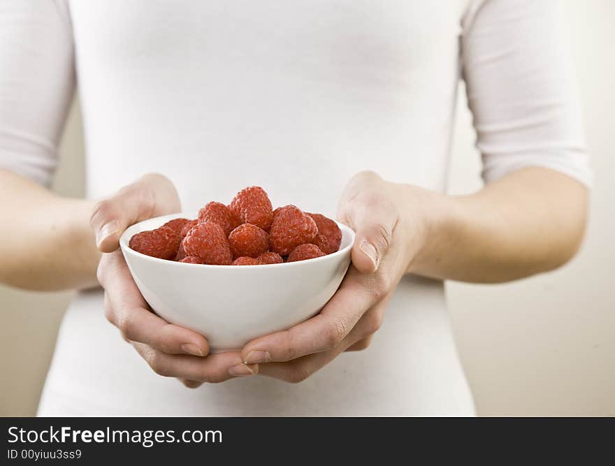 Close Up Of Woman Holding Bowl Of Raspberries