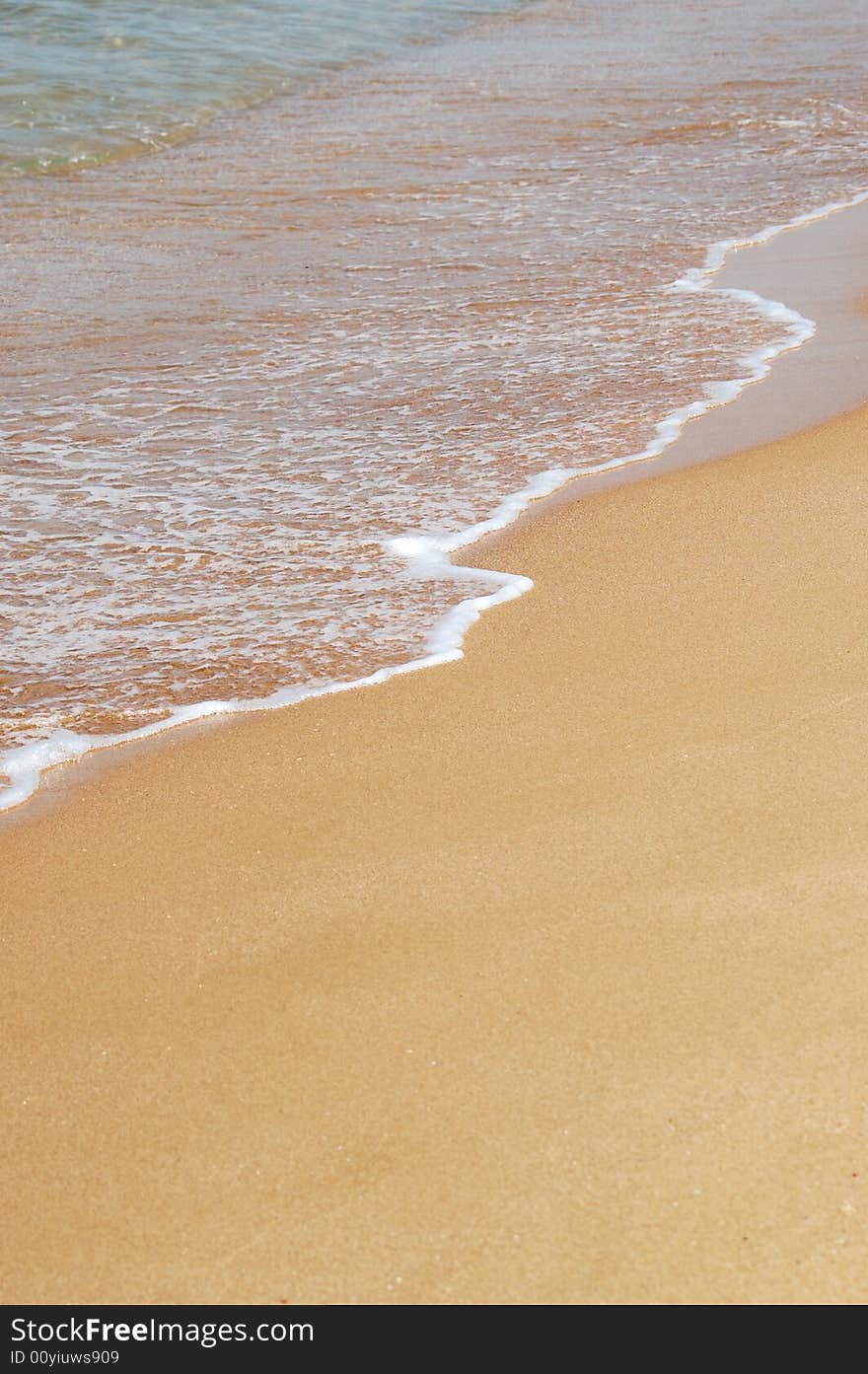 The point where the sea meets the sand on a sunny day at the beach. The point where the sea meets the sand on a sunny day at the beach