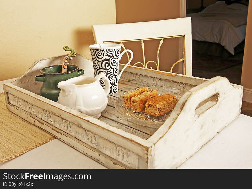 White French provincial tray with bran rusks , coffee cup, milkjar an sugerpot on table with chair. White French provincial tray with bran rusks , coffee cup, milkjar an sugerpot on table with chair