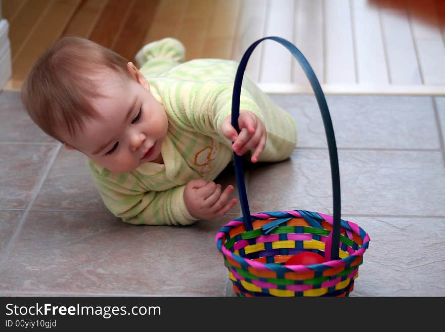 A baby boy in pajamas crawling to his Easter basket. A baby boy in pajamas crawling to his Easter basket