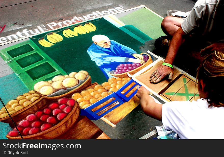 Husband and wife drawing together at a chalk drawing festival. Husband and wife drawing together at a chalk drawing festival.