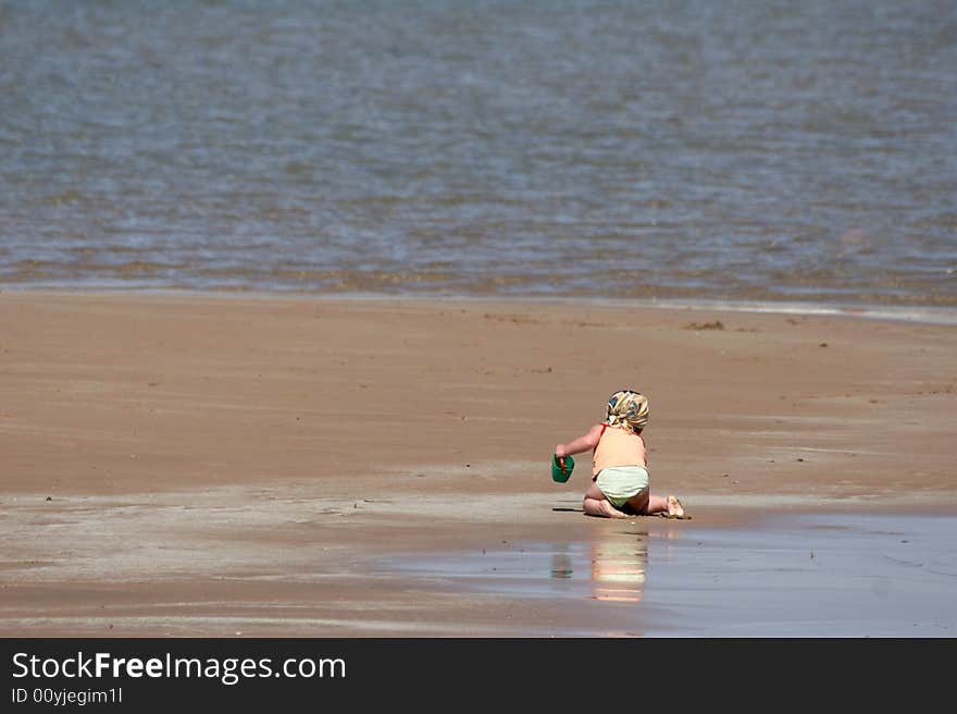 The child plays on a beach