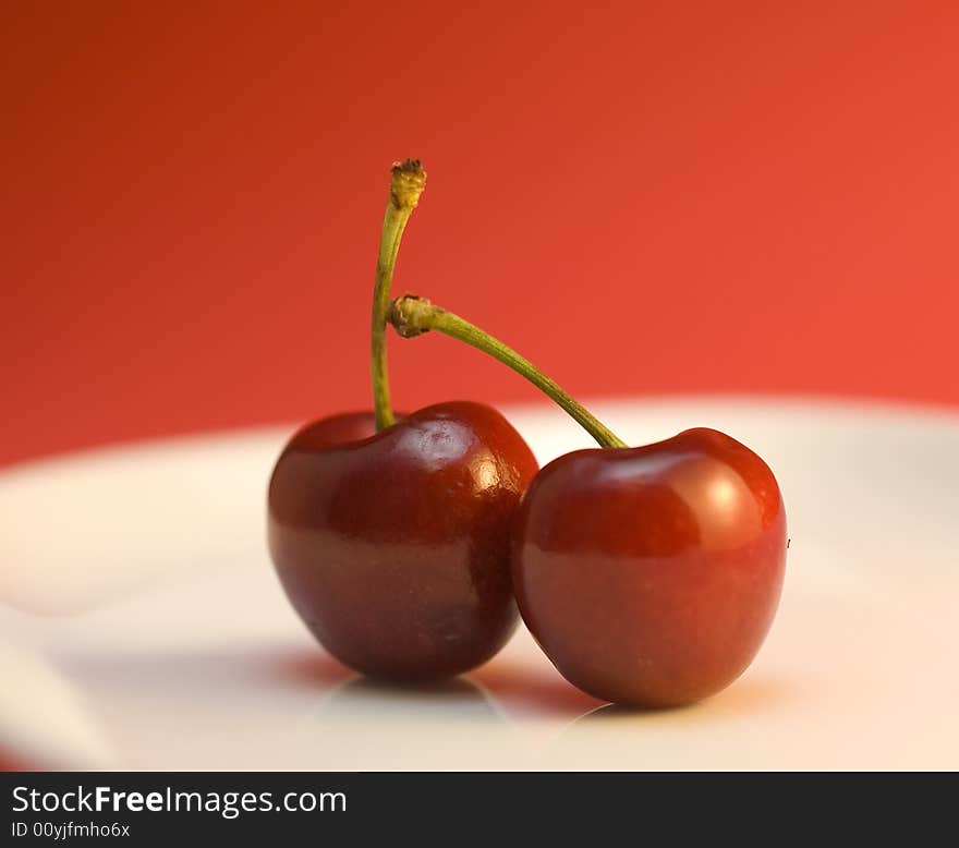 Two cherries on white plate. Two cherries on white plate.