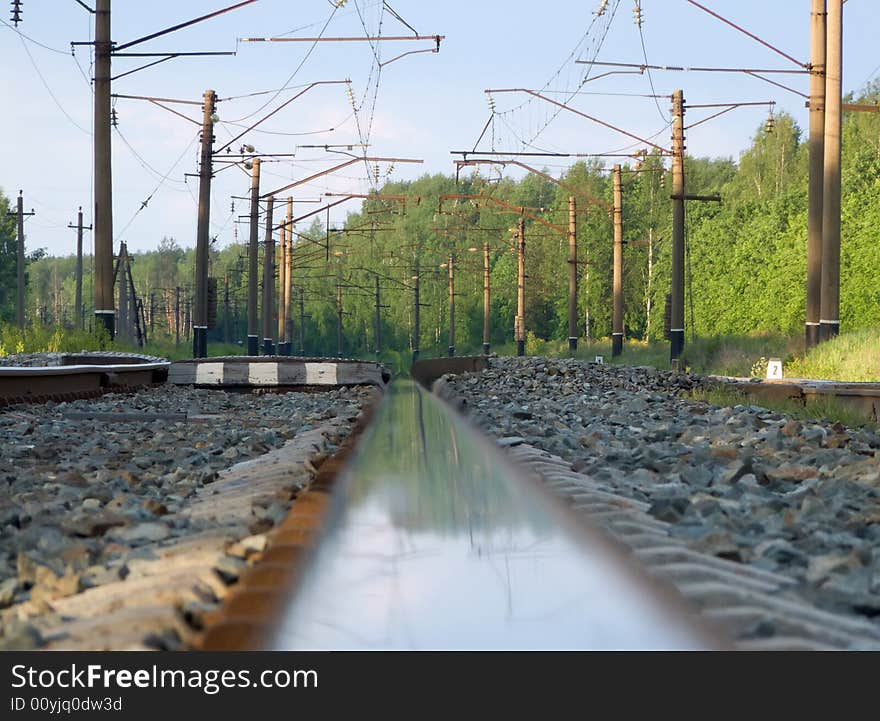 Straight railway track in summer sunrise