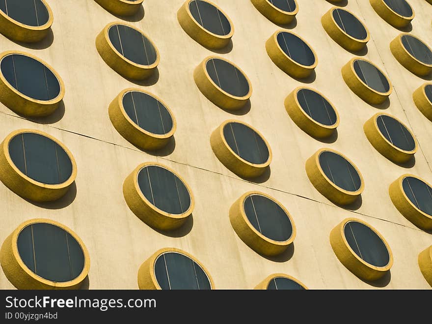 A detail image of the exterior wall of a modern building covered with round windows. A detail image of the exterior wall of a modern building covered with round windows