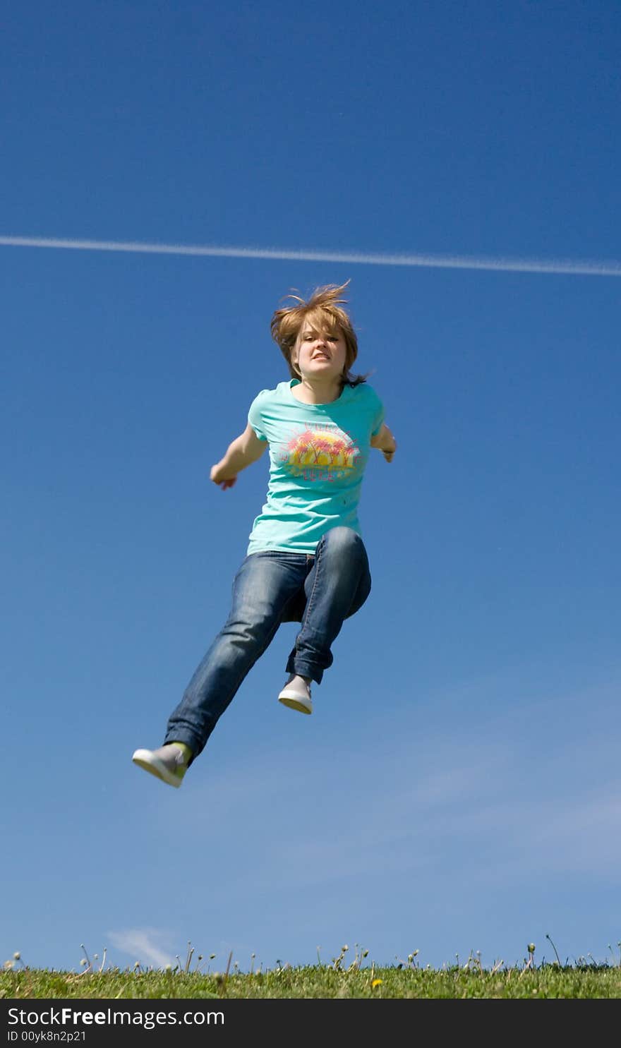 The young happy jumping girl on a background of the blue sky. The young happy jumping girl on a background of the blue sky