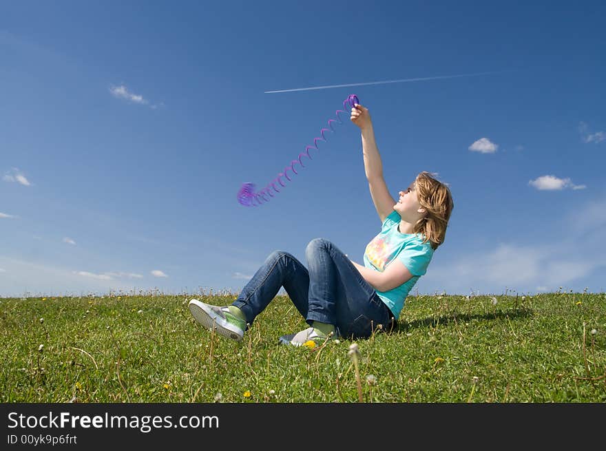 The young beautiful girl sitting on a green grass. The young beautiful girl sitting on a green grass