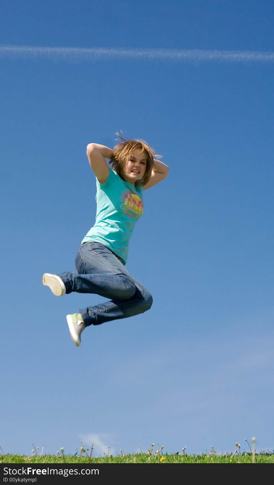 The young happy jumping girl on a background of the blue sky. The young happy jumping girl on a background of the blue sky