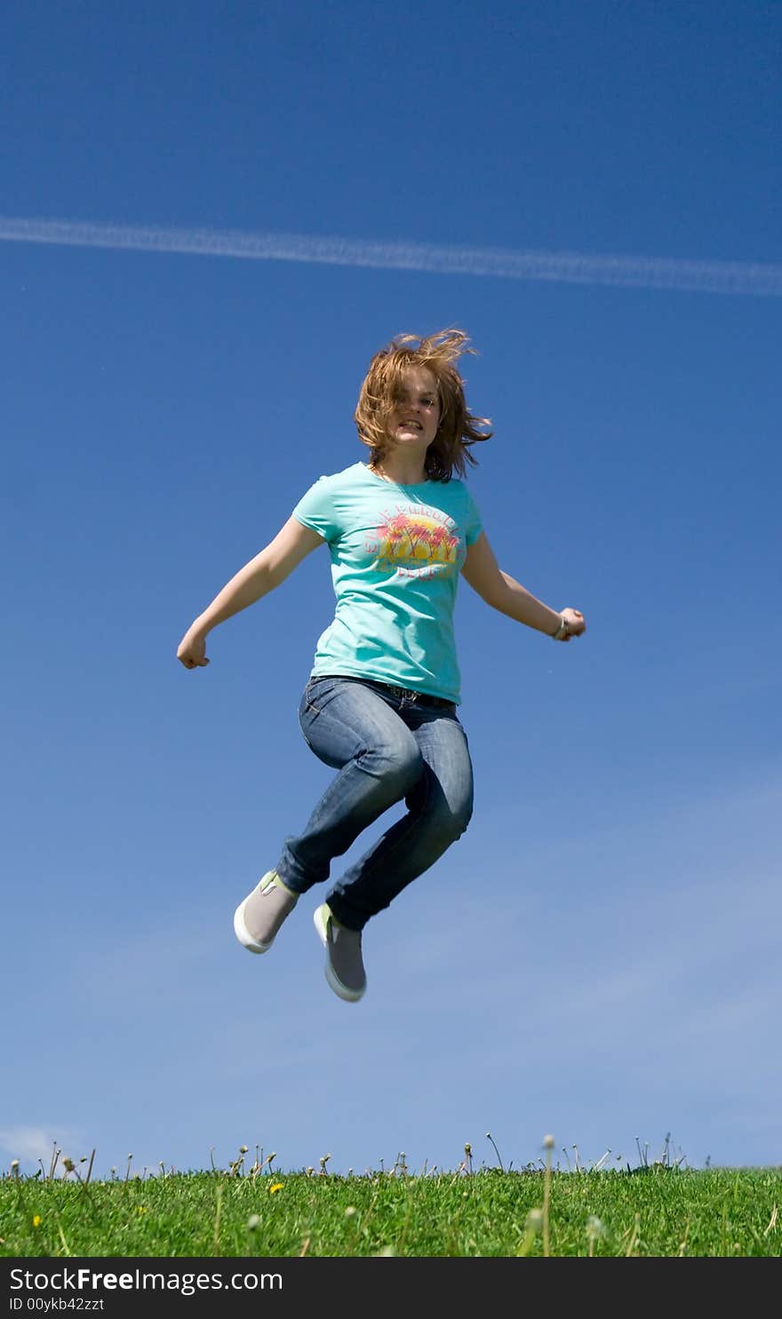 The young happy jumping girl on a background of the blue sky. The young happy jumping girl on a background of the blue sky