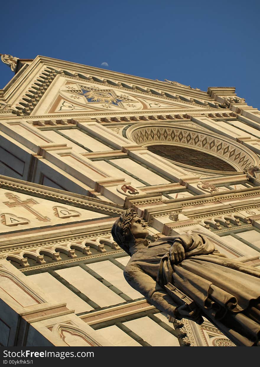 A view of the statue of Dante Alighieri and a glimpse of the facade of Santa Croce Church in Florence- Tuscany. A view of the statue of Dante Alighieri and a glimpse of the facade of Santa Croce Church in Florence- Tuscany