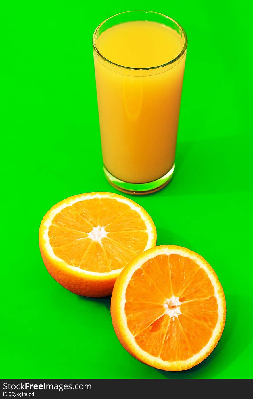 A tall glass of orange juice with oranges around it