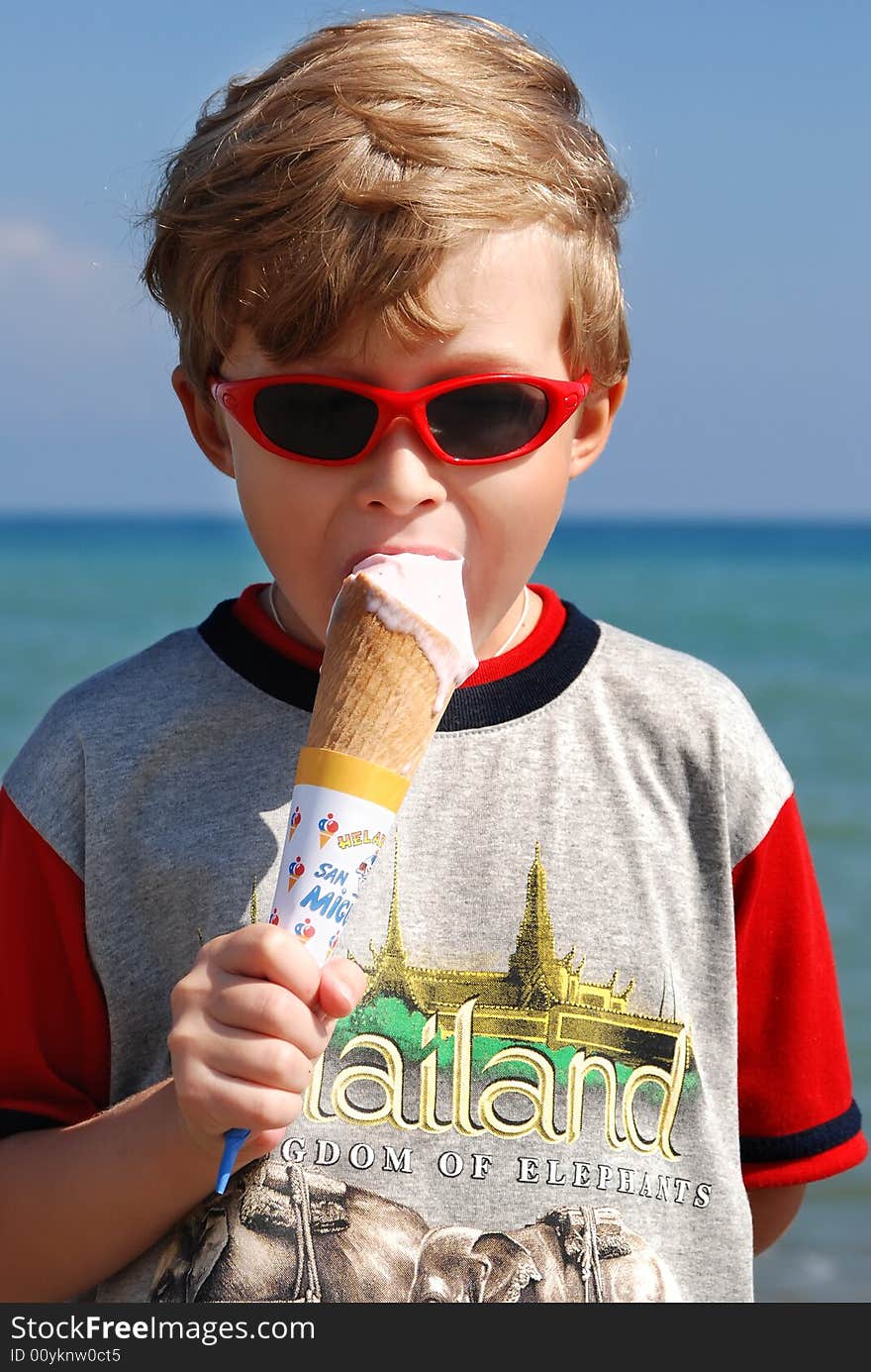 On seacoast the boy eats ice cream