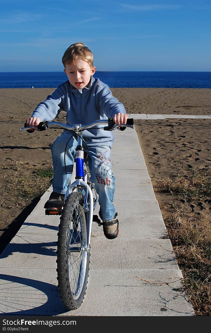 The happy boy goes for a drive on a bicycle