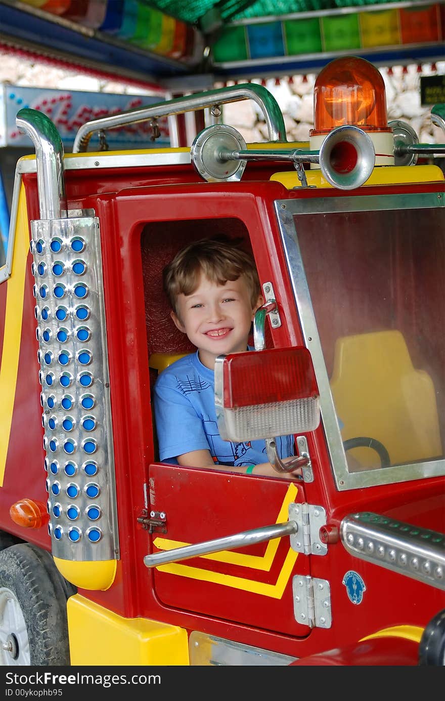 Cheerful and happy boy goes for a drive on roundabouts