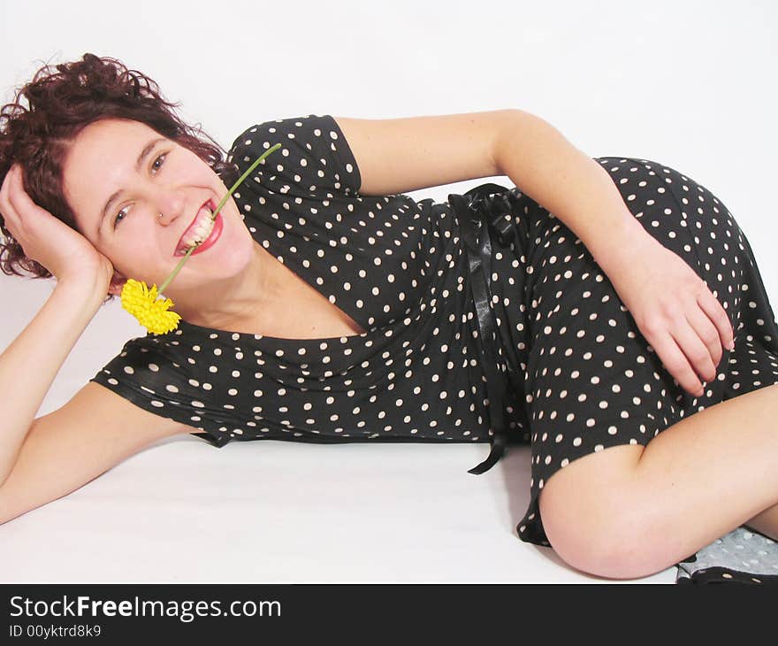 She is a happy young girl with a yellow flower and a black dress. She is a happy young girl with a yellow flower and a black dress.