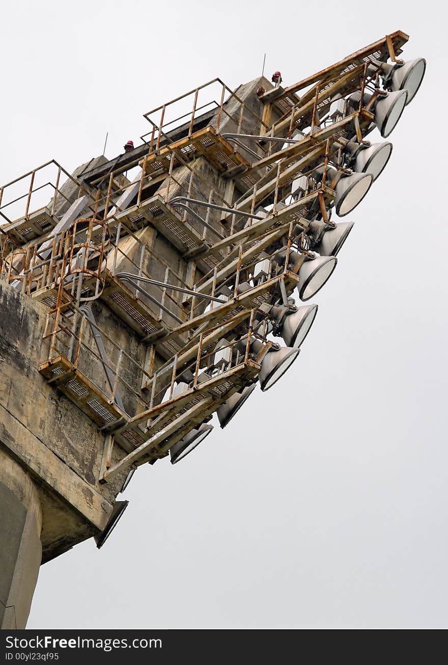 Floodlights atop a tower in a disused sports stadium. Floodlights atop a tower in a disused sports stadium