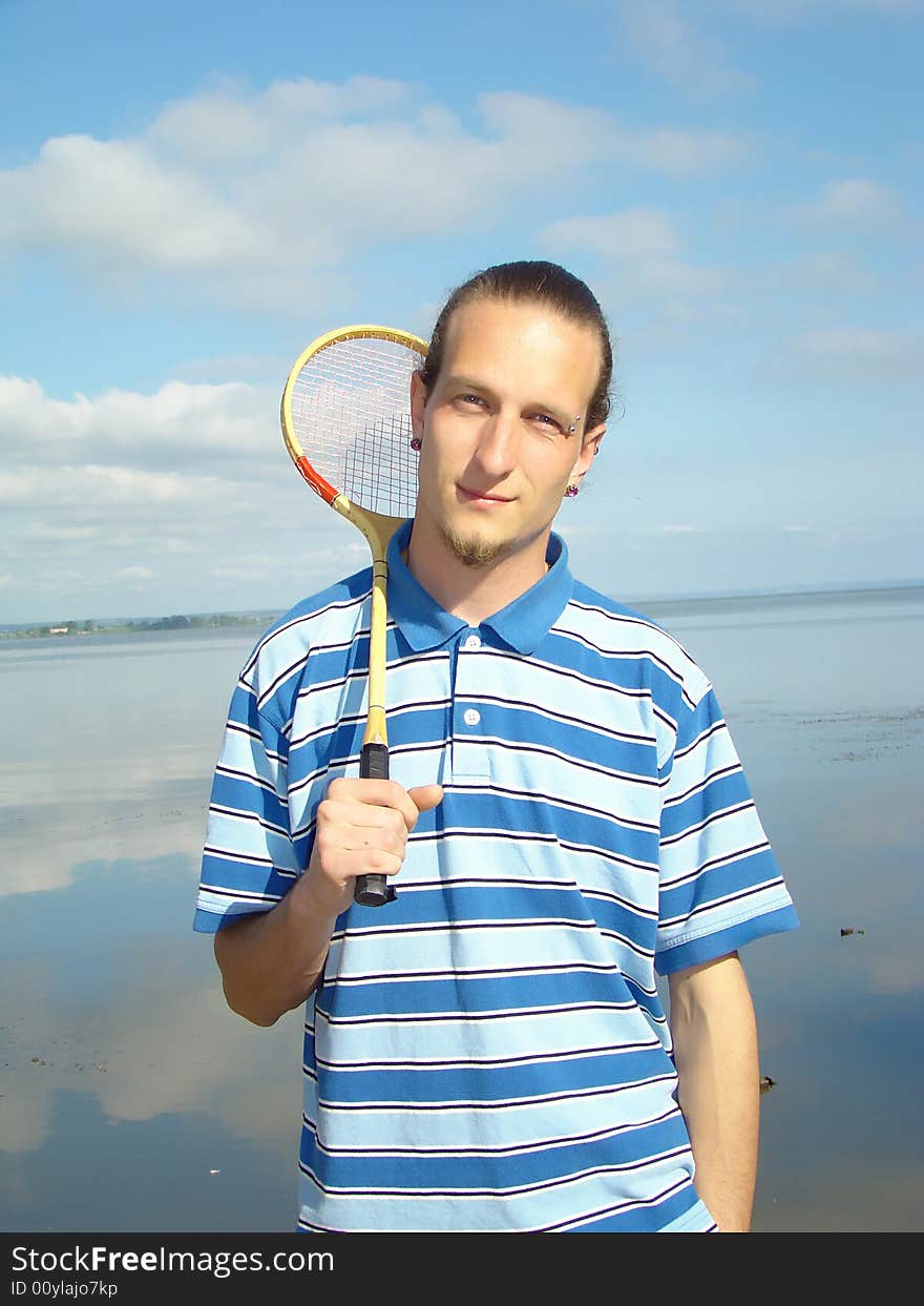 Youth rest. Thin fellow with a racket for a badminton on the riverside. Youth rest. Thin fellow with a racket for a badminton on the riverside.