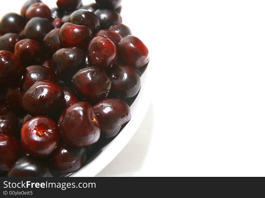 Sweet cherries in plate over white