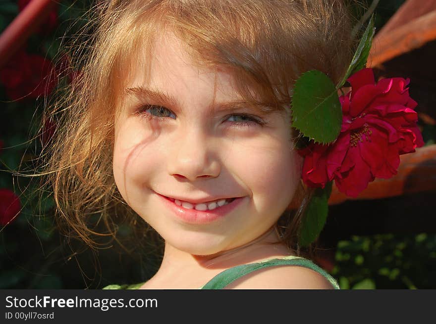 Beautiful little girl with a bright red rose. Beautiful little girl with a bright red rose