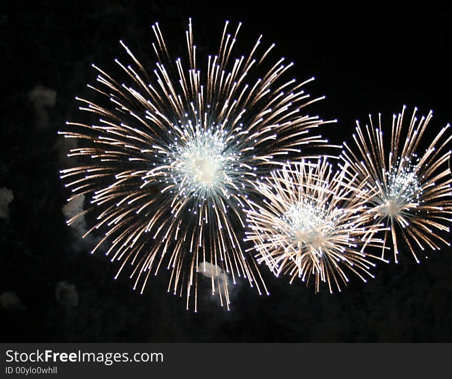 Fireworks exploding three white spheres. Fireworks exploding three white spheres