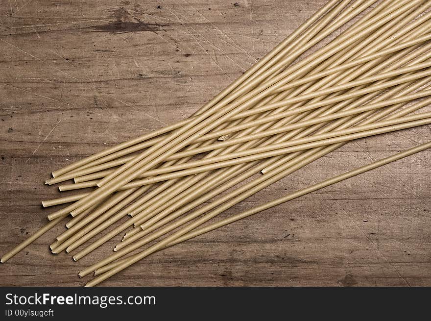 Italian spaguetti pasta dry, on wooden table.