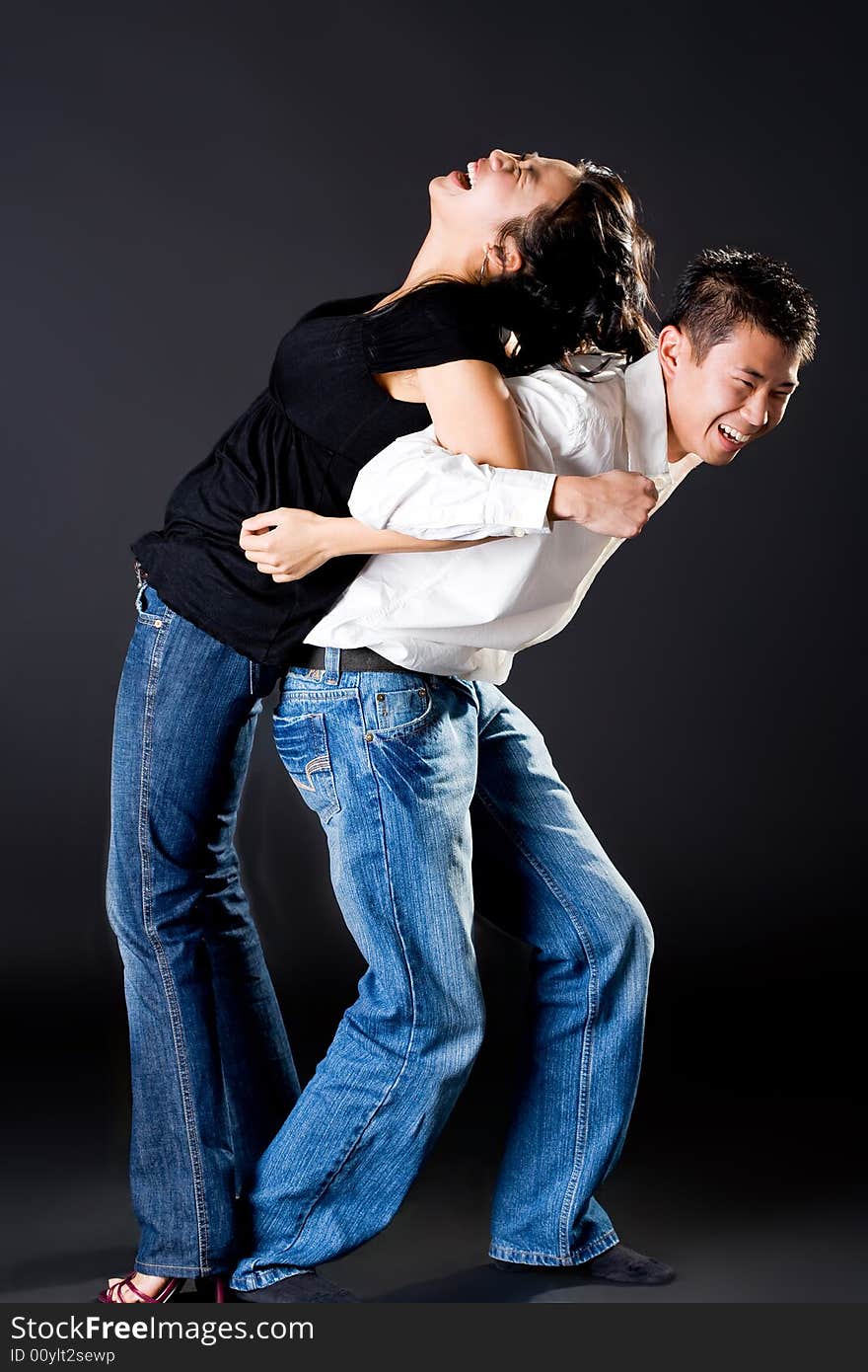 Asian young couple having fun with the guy try to carry up the girl. Asian young couple having fun with the guy try to carry up the girl