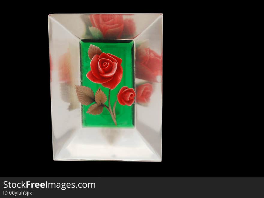 A bright red rose encased in plastic with reflections, isolated on black. A bright red rose encased in plastic with reflections, isolated on black