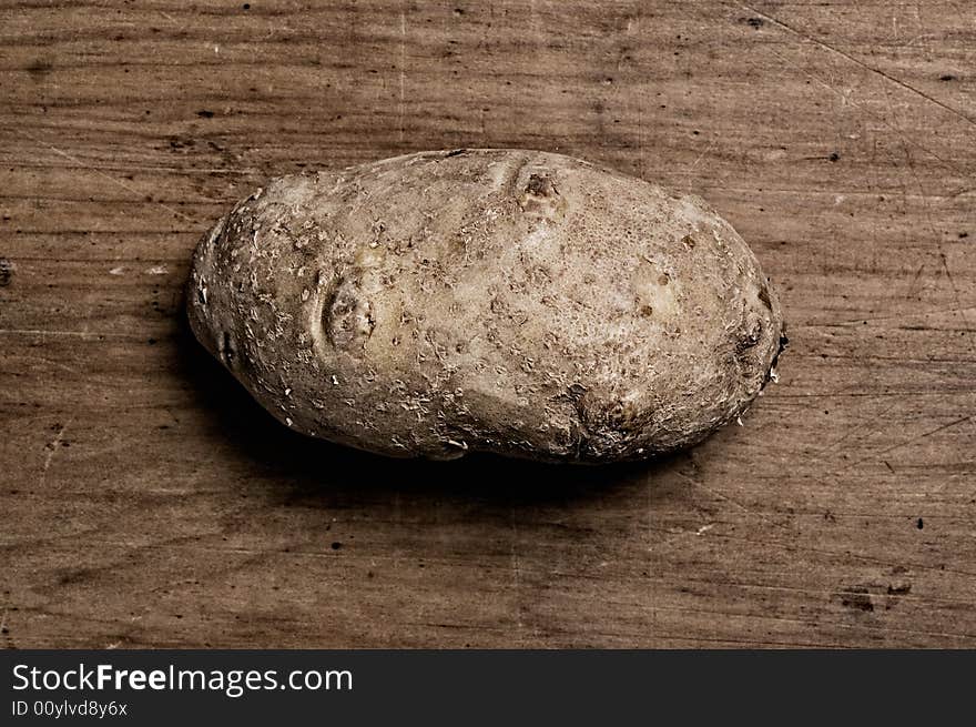 Potato on old wooden table.