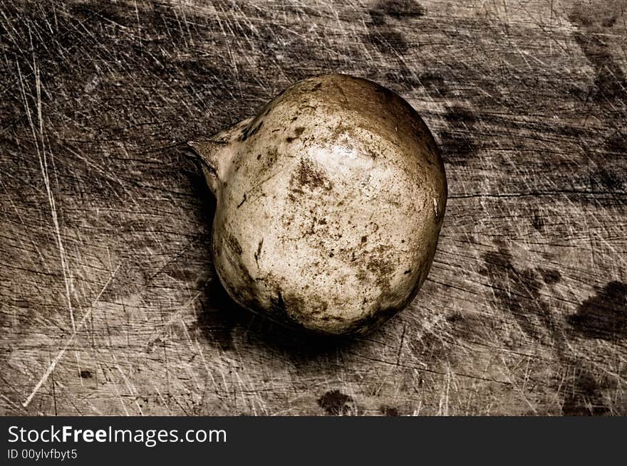 A pomegranate isolated on a wooden table. A pomegranate isolated on a wooden table.