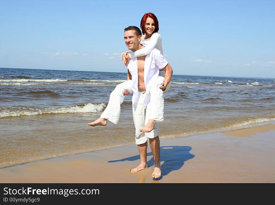 Beautiful yound couple relaxing on the beach. Beautiful yound couple relaxing on the beach