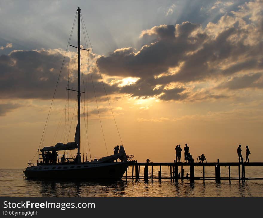 The Black sea, the sunset, and the silhouette of the yacht near the mooring line. The Black sea, the sunset, and the silhouette of the yacht near the mooring line