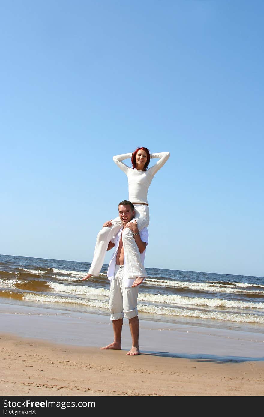 Beautiful yound couple relaxing on the beach. Beautiful yound couple relaxing on the beach