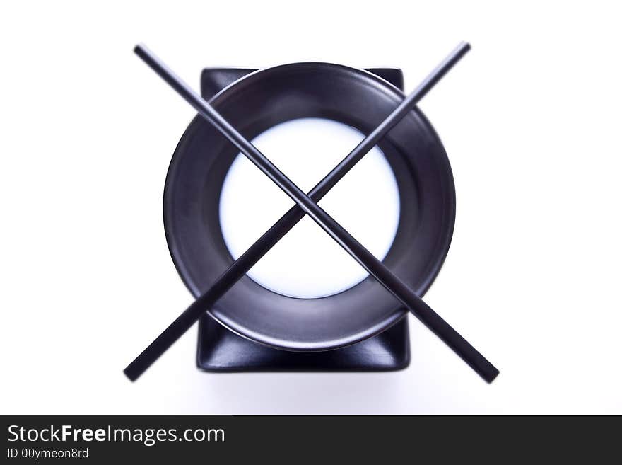 A japanese plate and a bowl displayed in a simetrical way. This picture was take from high pisition in a studio.The bowl contained milk so it could contrast with the colour black. A japanese plate and a bowl displayed in a simetrical way. This picture was take from high pisition in a studio.The bowl contained milk so it could contrast with the colour black.