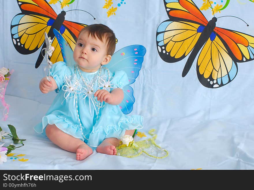 A picture of a sweet little girl in a fancy blue dress with butterfly wings. A picture of a sweet little girl in a fancy blue dress with butterfly wings