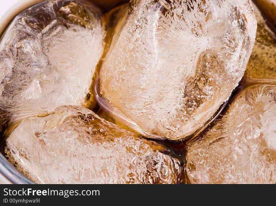 Cold fizzy cola with ice in a glass. Close up. Abstract background.