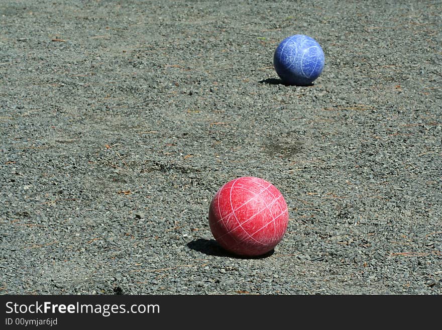 Red and blue bocce balls on a court