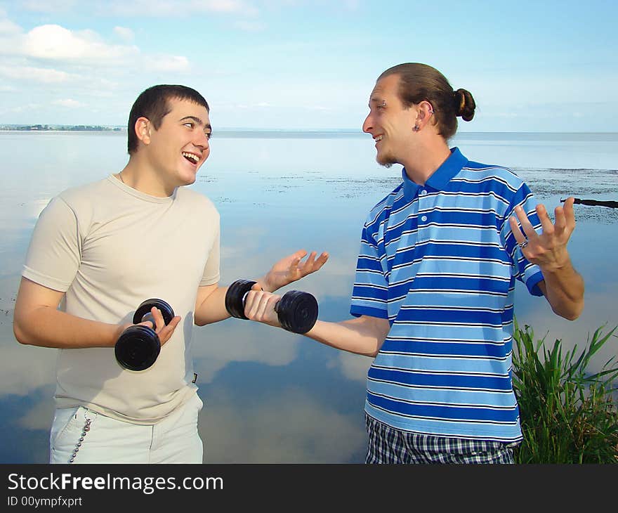 Youth funs. Two fellows with dumb-bells. Healthy lifestyle. Youth funs. Two fellows with dumb-bells. Healthy lifestyle.