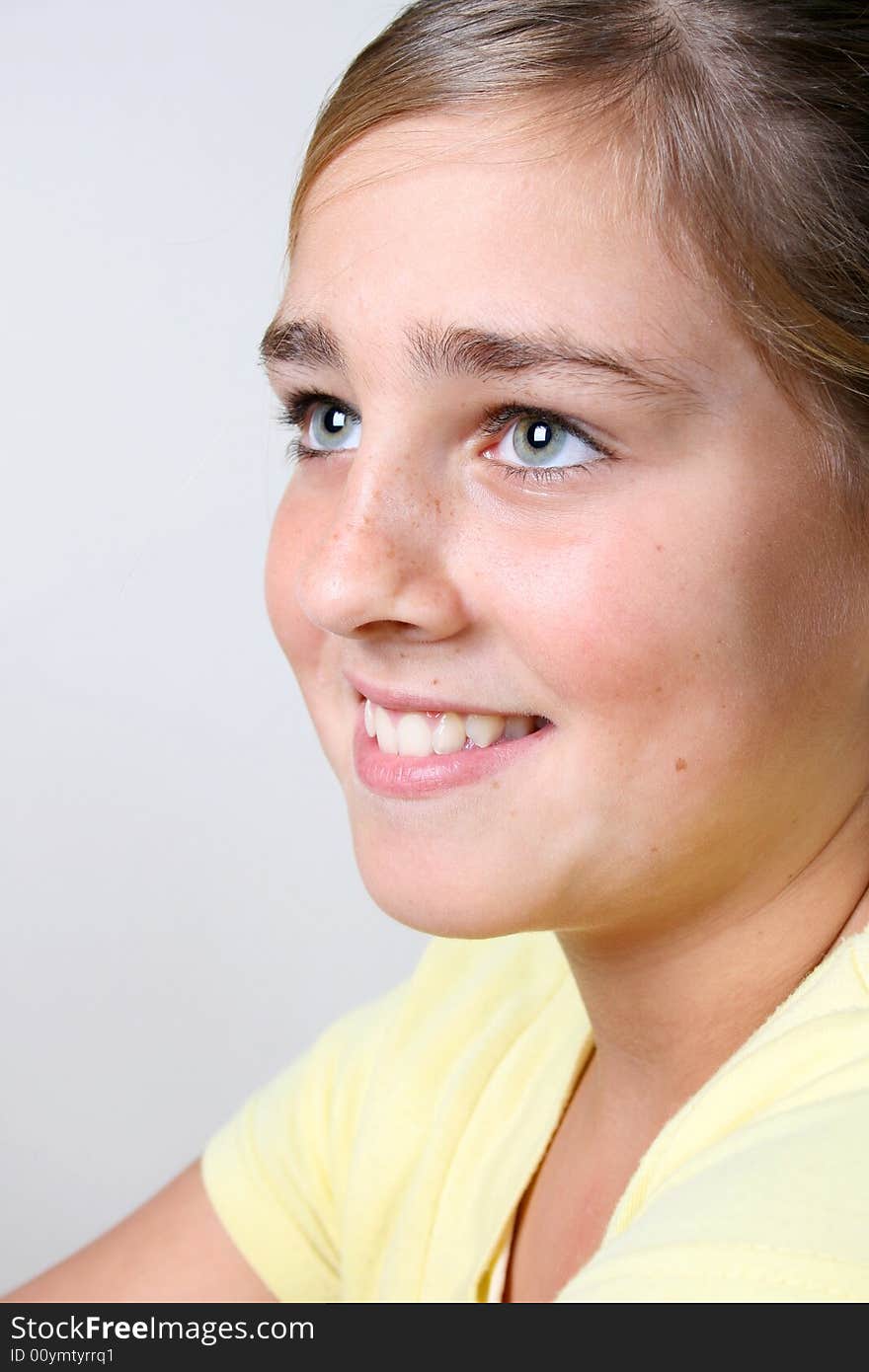 Young girl with beautiful eyes wearing a yellow top